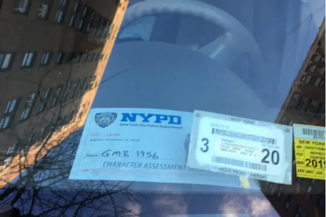 A vehicle displaying an NYPD placard from the "Character Assessment Unit" blocks the bus lane on Second Avenue